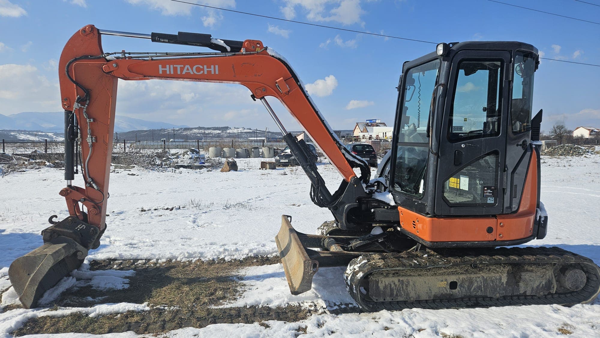 Miniexcavator Hitachi al HCN Construct pe un teren înzăpezit din Sibiu